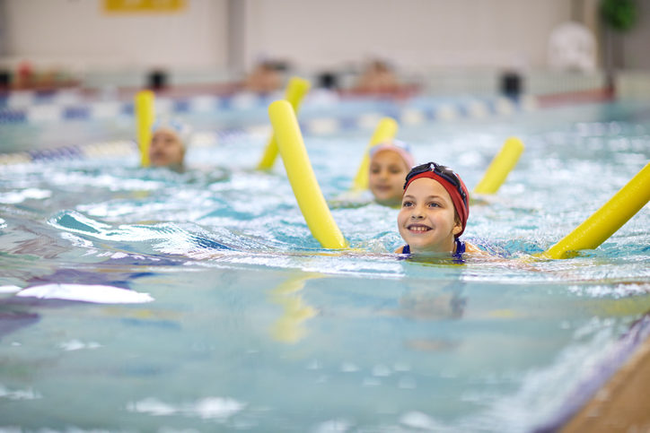 Little girl with swimming noodle